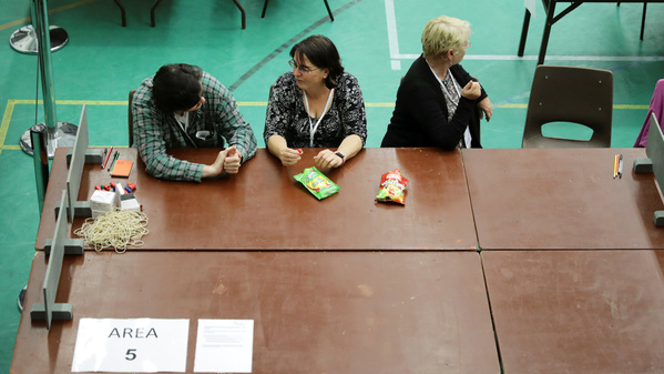 Rösträknare väntar på att valurnorna ska komma i en vallokal i Hastings. Foto: TT