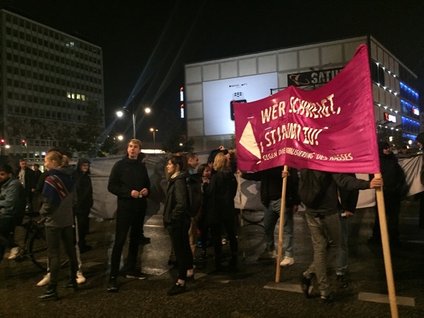 "Den som tiger håller med! ", står det på ett plakat som en grupp demonstranter håller upp utanför AFD:s valvaka vid Alexanderplatz.