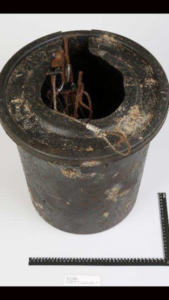 Svart tunna med hål och snaror som hittades i en blå platssäck på 37-åringens flak. Foto: Polisen