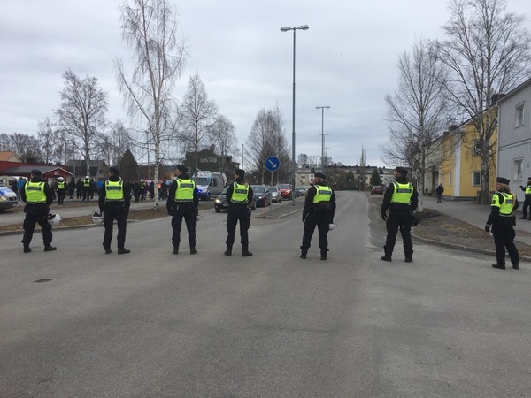 Polisen blockerar Kungsgatan. Motdemonstranterna försöker skrika till NMR.