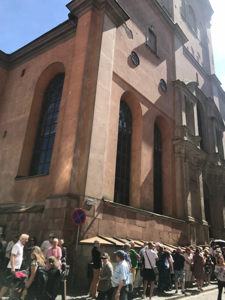 Kön utanför kyrkan är redan lång. Någon har fällt upp ett paraply som skydd mot den stekande solen. Det är en varm, solig majdag då Stockholm tar farväl av en älskad artist.