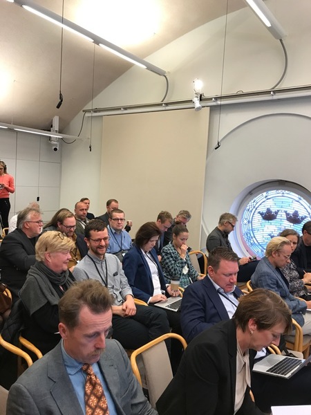 Nästan fullt i pressrummet utanför plenisalen. Alla väntar på Stefan Löfven.