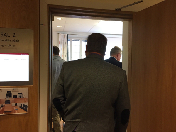 Förhandlingarna hålls i en mindre sal på Hudiksvalls tingsrätt. Bland åhörarna finns, utöver journalister, några privatpersoner som är intresserade av målet.