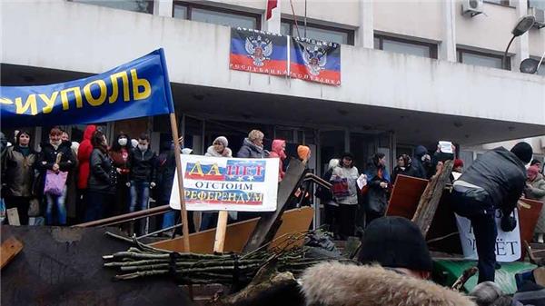 Demonstranter utanför borgmästarens kontor i staden Mariupol, drygt 30 mil söder om Slovjansk. Enligt uppgifter från Reuters ska byggnaden ha ockuperats. Foto: TT