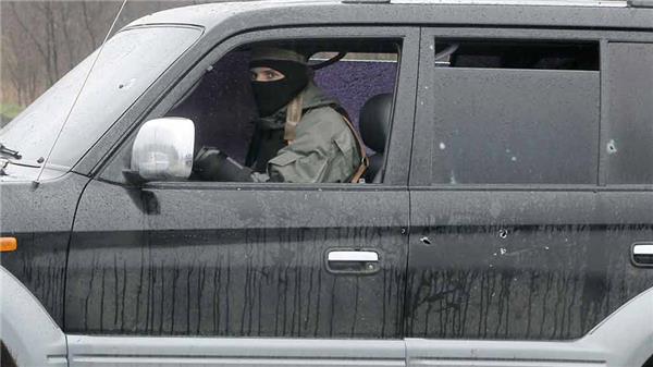 En pro-rysk aktivist kör iväg i en bil som skottskadats under eldstriderna utanför Slovjansk. Foto: TT/AFP