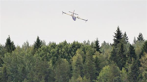 Ett av de fyra vattenbombningplanen av typ CL-415 flyger över sjön Åmänningen i skogsbrandsområdet nära Karbennign i Västmanland på onsdagen.
TT