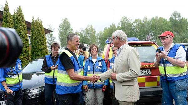 Kungen hälsar på brandfrivilliga i Ramnäs. Foto: TT