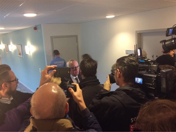 Den misstänktes försvarare intervjuas av pressuppbådet.